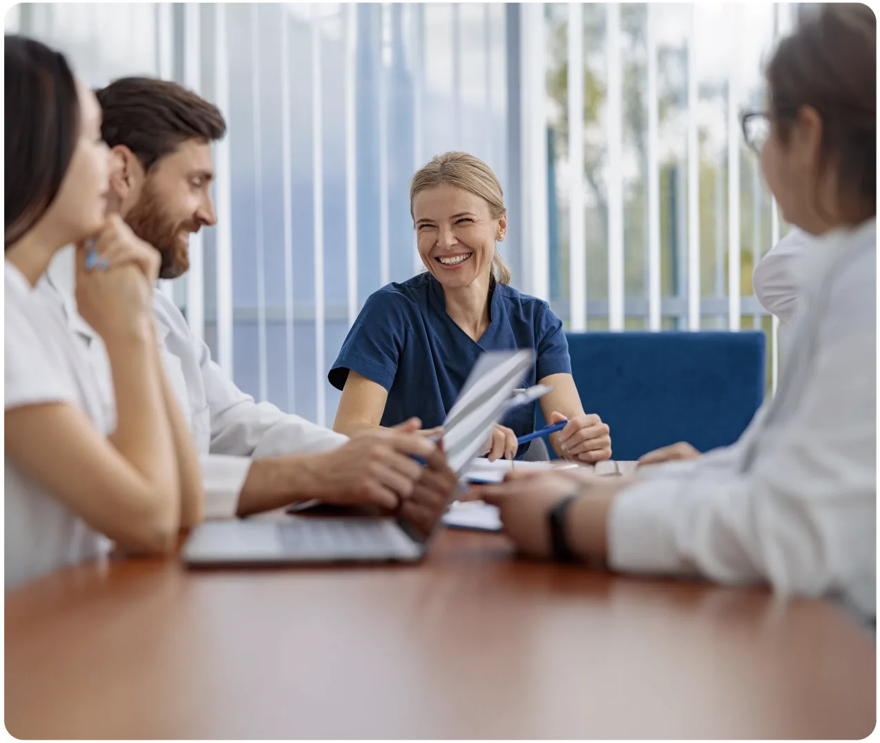 Smiling Nurse Leading Healthcare Staff Briefing in Conference Room Smiling Nurse Leading Healthcare Staff Briefing in Conference Room